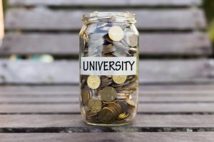 Coins in jar labelled university by Shutterstock.com/JeJai Images
